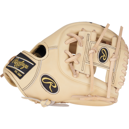 The Rawlings Heart of the Hide 11.25" Baseball Glove (PROR312-2CB) is a tan infield glove with black and gold accents, visible stitching, leather laces, a Pro-I web, and showcases detailed craftsmanship with signature brand patches.