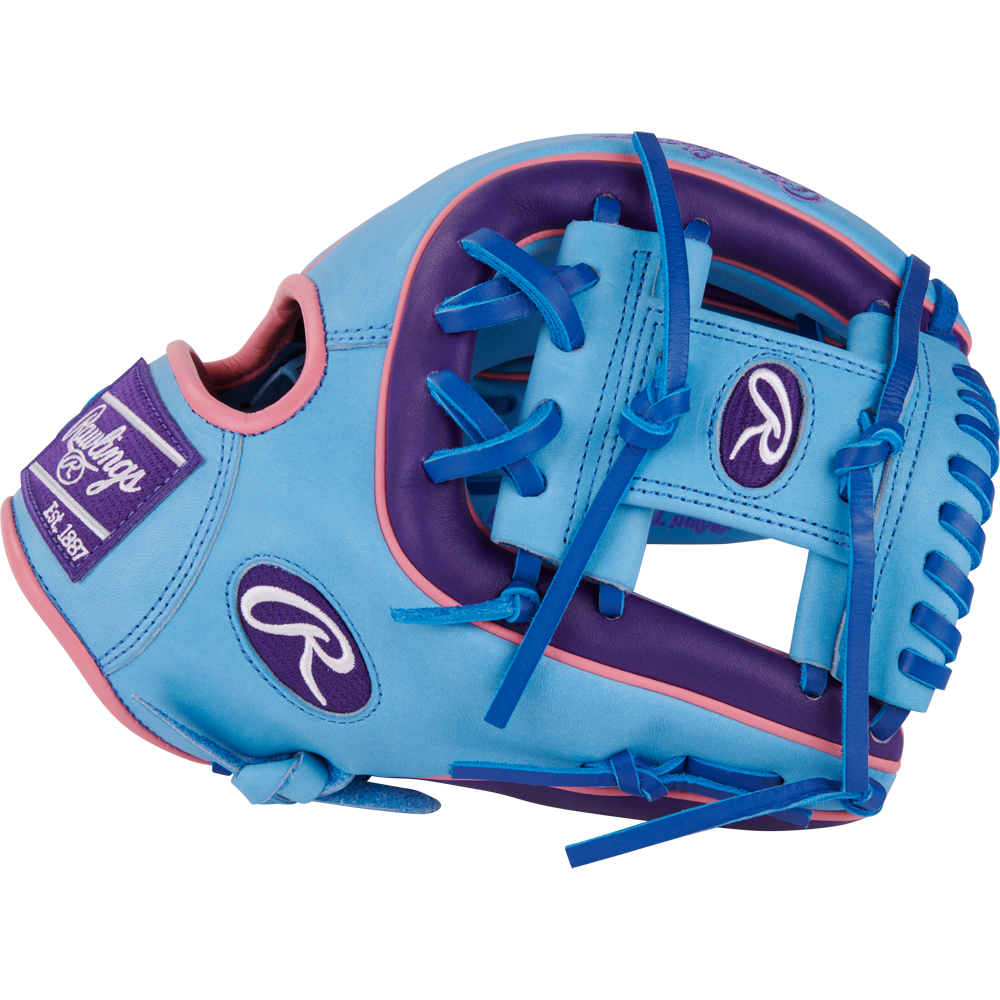 The Rawlings Heart of the Hide 11.5" Color Sync Baseball Glove (PROR314-2CBPU) is a blue and purple infield glove with pink accents, blue laces, and features the Rawlings logo plus “Est. 1887” on a patch.