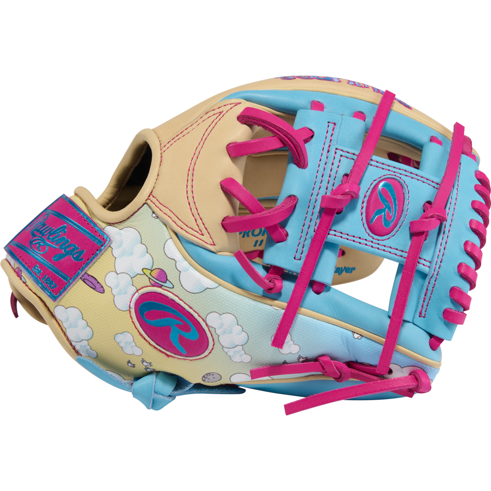 The Rawlings Heart of the Hide Icon Fest 11.5" Baseball Glove (PROR934-2CBE) features premium steerhide leather in cream, blue, and pink with cloud patterns, pink laces, and Heart of the Hide logos on the wrist strap and thumb.
