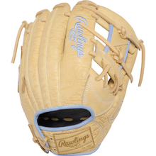 A tan Rawlings Heart of the Hide 11.5″ baseball glove (model PRORB734-2XC), featuring light blue accents and lacing, with embroidered branding on both the glove’s surface and wrist strap.