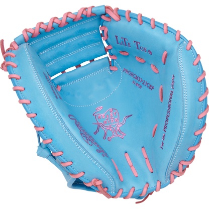 The Rawlings Heart of the Hide 33" Catcher's Mitt (PRORCM33-23CBP) features a blue design with pink lacing and stitching, the iconic Rawlings logo, and detailed text inside the glove.