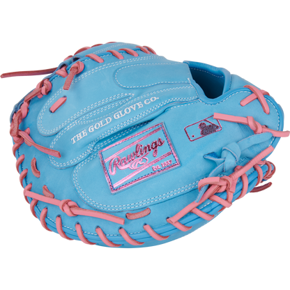 The Rawlings Heart of the Hide 33" catcher's mitt (PRORCM33-23CBP) is light blue with pink laces, stitching, and a pink Rawlings logo patch. It features "THE GOLD GLOVE CO." stamped on the outer side.