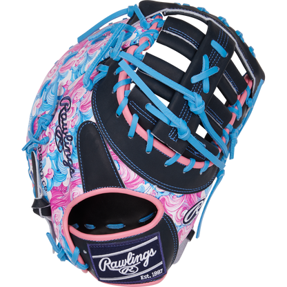 The Rawlings Heart of the Hide 13" ColorSync First Base Mitt (PRORDCT-10NSS) features swirling pink, blue, and white patterns with navy webbing and blue laces. The Rawlings logo appears on the thumb and wrist strap.
