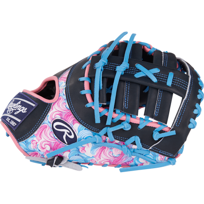The Rawlings Heart of the Hide 13" Color Sync First Base Mitt (PRORDCT-10NSS) features a black base, blue and pink laces, swirling pink and blue thumb/palm, white stitching, and the Rawlings logo.