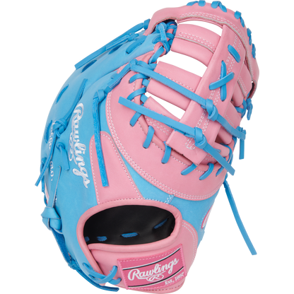 A Rawlings Heart of the Hide 12.25" First Base Mitt (PRORDCTU-10PCB) features a pink and blue design with blue laces and white branding, displayed against a plain white background.