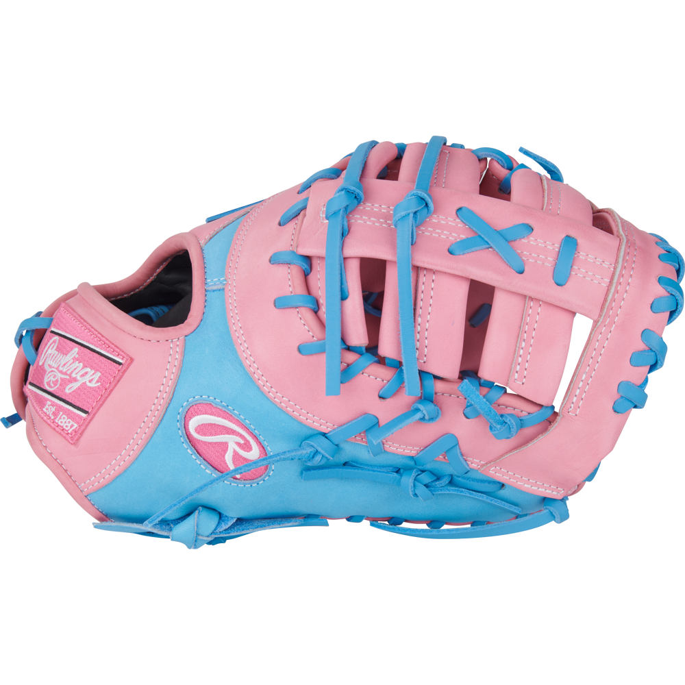The Rawlings Heart of the Hide 12.25" First Base Mitt (PRORDCTU-10PCB) features a pink and light blue design with blue laces, pink patches, ContoUR Fit, and bold Rawlings branding on the thumb.