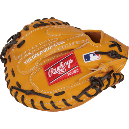 The Rawlings Heart of the Hide 33" Catcher's Mitt (RPROTCM33T) features a tan design with black laces, THE GOLD GLOVE CO. stitching, a red Rawlings patch, and a white MLB logo patch on the outside.