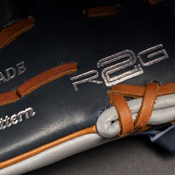 Close-up of a black and brown baseball glove with visible stitching and embossed text reading R2G and Pattern.