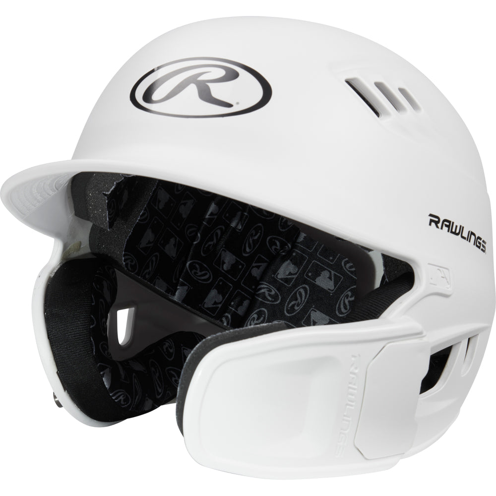 The Rawlings R16 Matte Batting Helmet with Universal Jaw Guard (R6R07) features a white finish, ventilation holes, Rawlings logos on the front and side, and black interior padding with a repeating Rawlings logo pattern.