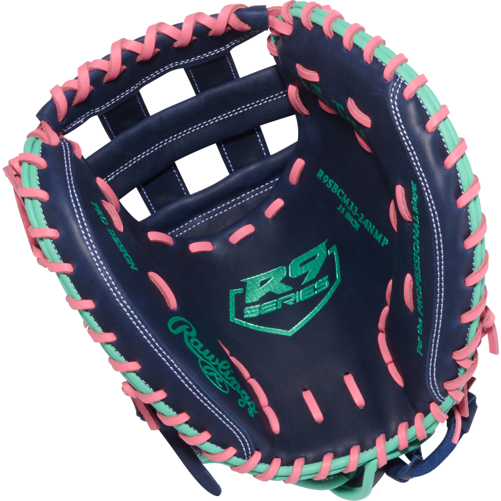 The Rawlings R9 33" Fastpitch Catcher's Mitt (R9SBCM33-24NMP) features navy blue leather with pink and mint lacing, RS Series and green Rawlings logos—an eye-catching softball glove built for elite catchers.
