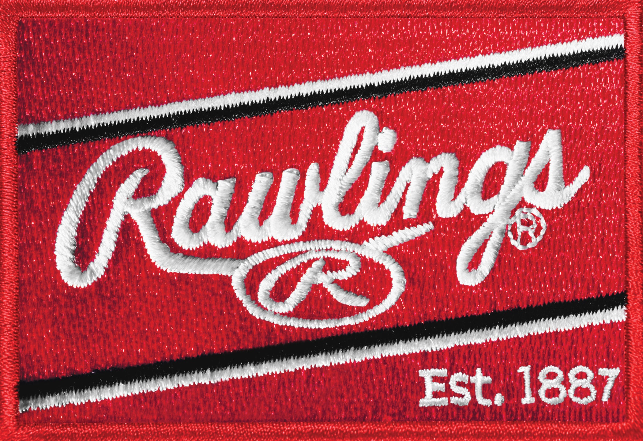 A red embroidered patch with white diagonal stripes and the word Rawlings in cursive, a circled R below, and Est. 1887 in the bottom right corner.