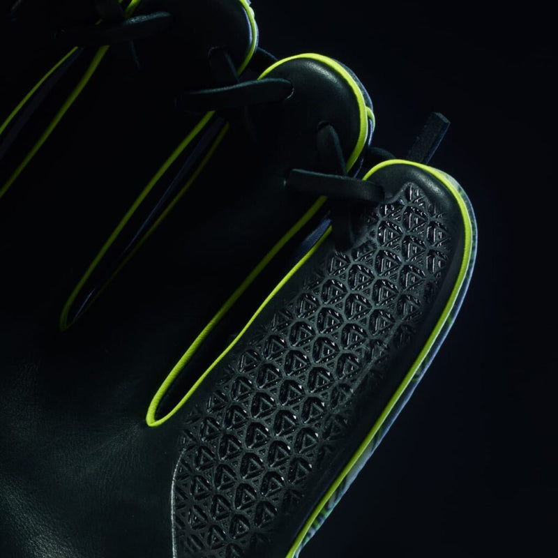 Close-up of a black glove with neon yellow accents and a textured, geometric pattern on the fingers, set against a dark background.