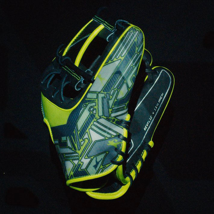 A black and neon yellow baseball glove with geometric patterns is displayed against a dark background. The gloves fingers and edges are outlined in yellow, and text is visible on the palm’s inside.