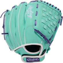 The Rawlings Sure Catch 11.5" Fastpitch Glove (SCSB115MW) is a teal youth glove with purple laces, white trim, branding on the wrist strap, woven web design, and "THE GOLD GLOVE CO." text on the thumb.