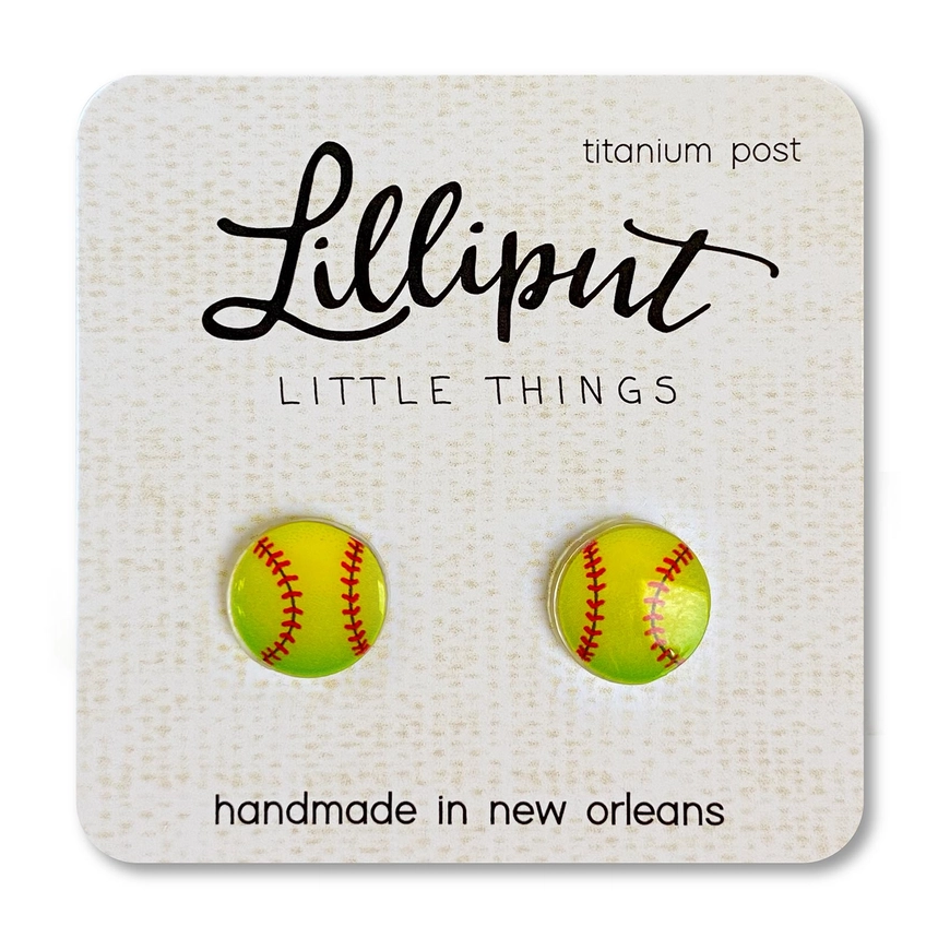 Lilliput Little Things Earrings feature hypoallergenic, handmade yellow softball shapes with red stitching, displayed on a branded card reading “Lilliput Little Things, titanium post, handmade in New Orleans.”.
