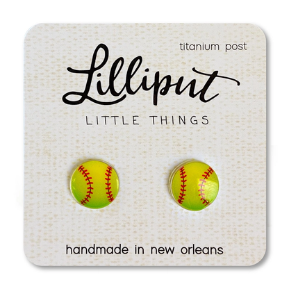 Lilliput Little Things Earrings feature hypoallergenic, handmade yellow softball shapes with red stitching, displayed on a branded card reading “Lilliput Little Things, titanium post, handmade in New Orleans.”.