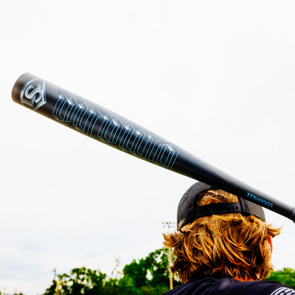 A person holding a 2025 Louisville Slugger Omaha (-3) BBCOR Baseball Bat (WBL2984010) with a one-piece EVOKE Alloy Barrel.