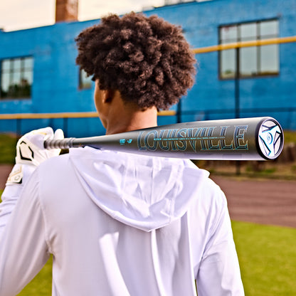 A person holding the 2025 Louisville Slugger Omaha (-3) BBCOR Baseball Bat (WBL2984010), a powerful one-piece alloy bat featuring the brand's signature EVOKE Alloy Barrel.