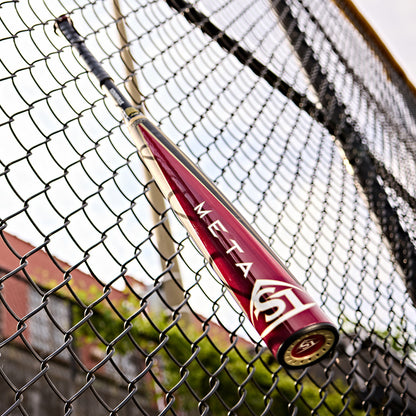 A 2025 Louisville Slugger Meta (-3) BBCOR Baseball Bat: WBL2966010 (USED) sits on a fence, its EKO Composite Barrel and two-piece composite design poised for the next big hit.