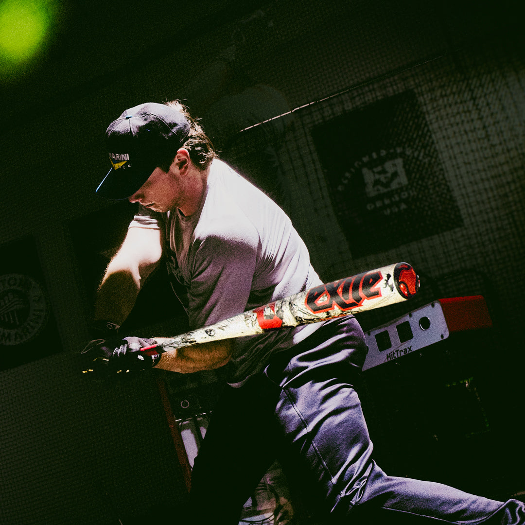 A man holding the 2026 DeMarini Exile (-3) BBCOR Baseball Bat (WBD2589010) by DeMarini.