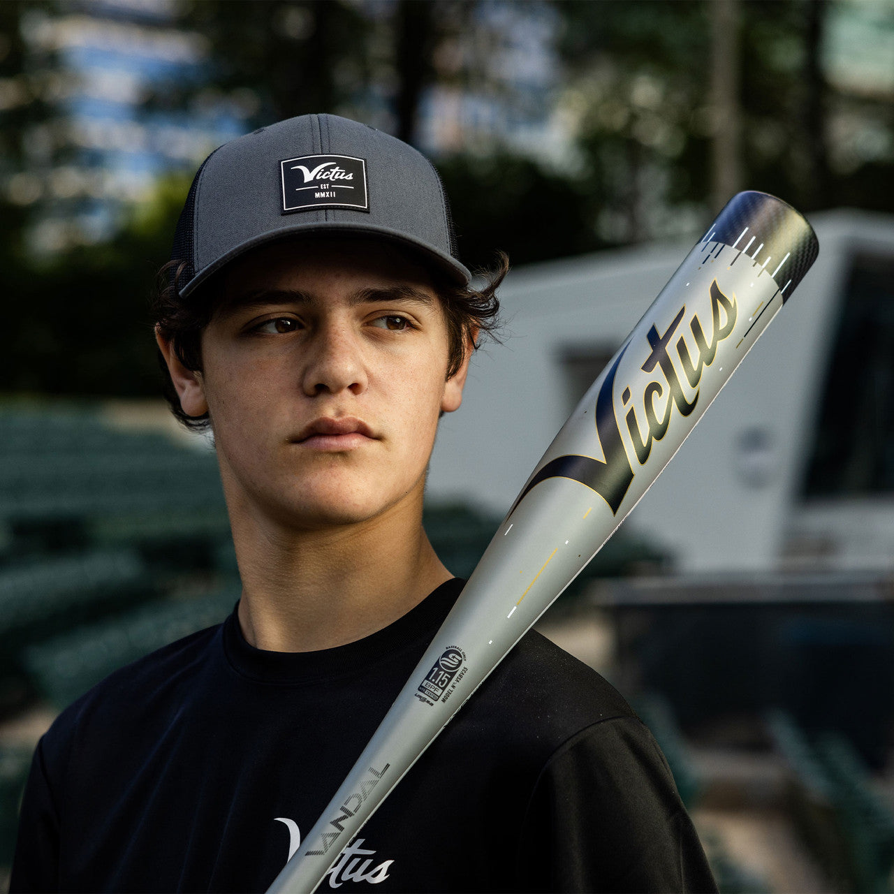 A boy holding a 2024 Victus Vandal Lev3 (-5) 2 3/4" USSSA Baseball Bat: VSBV35-DM (USED), ready to swing.