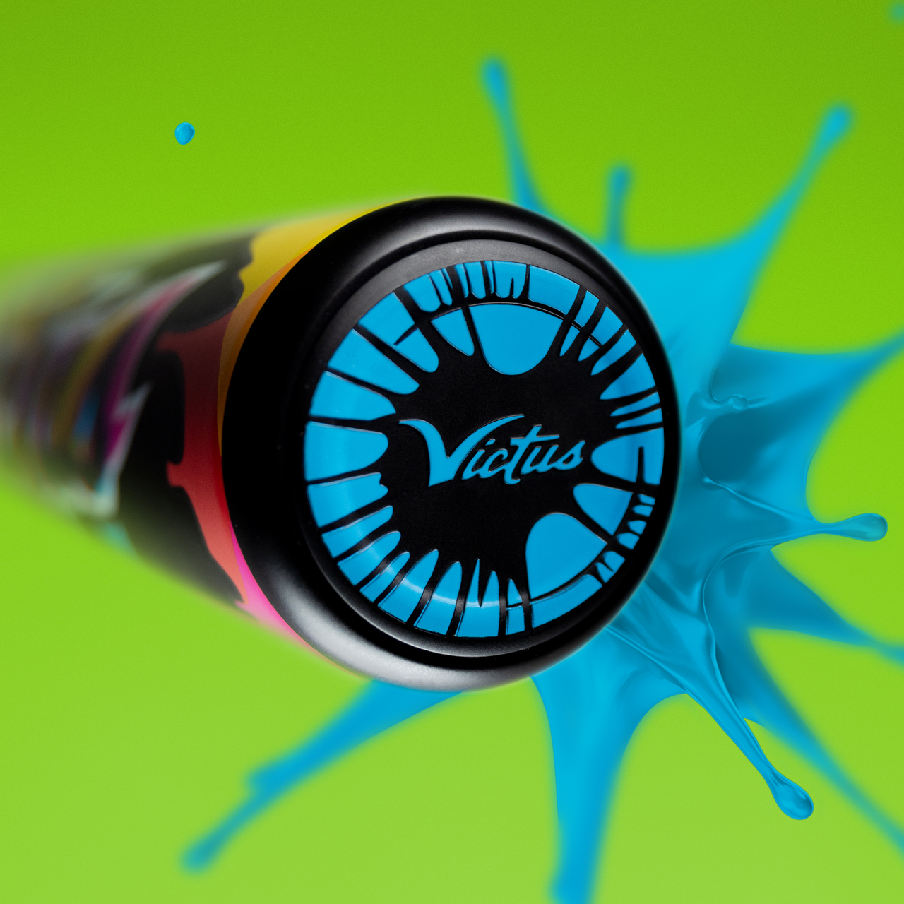 A close-up of the 2024 Victus Vibe (-10) 2 3/4" USSSA Baseball Bat by Victus, featuring a blue paint splash, aluminum construction, and vibration reducing knob, set against a bright green background.