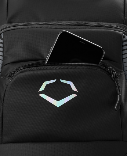 The EvoShield Tone Set Backpack (WB57304) by EvoShield is a black, water resistant backpack featuring a holographic geometric logo and bat sleeves for versatile use—shown partially unzipped with a black smartphone inside.