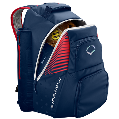 The EvoShield Tone Set Backpack: WB57304 by EvoShield, in USA colors, features multiple compartments, bat sleeves, a water-resistant design, and displays the EvoShield logo on the front pocket. A baseball glove is partially visible inside.