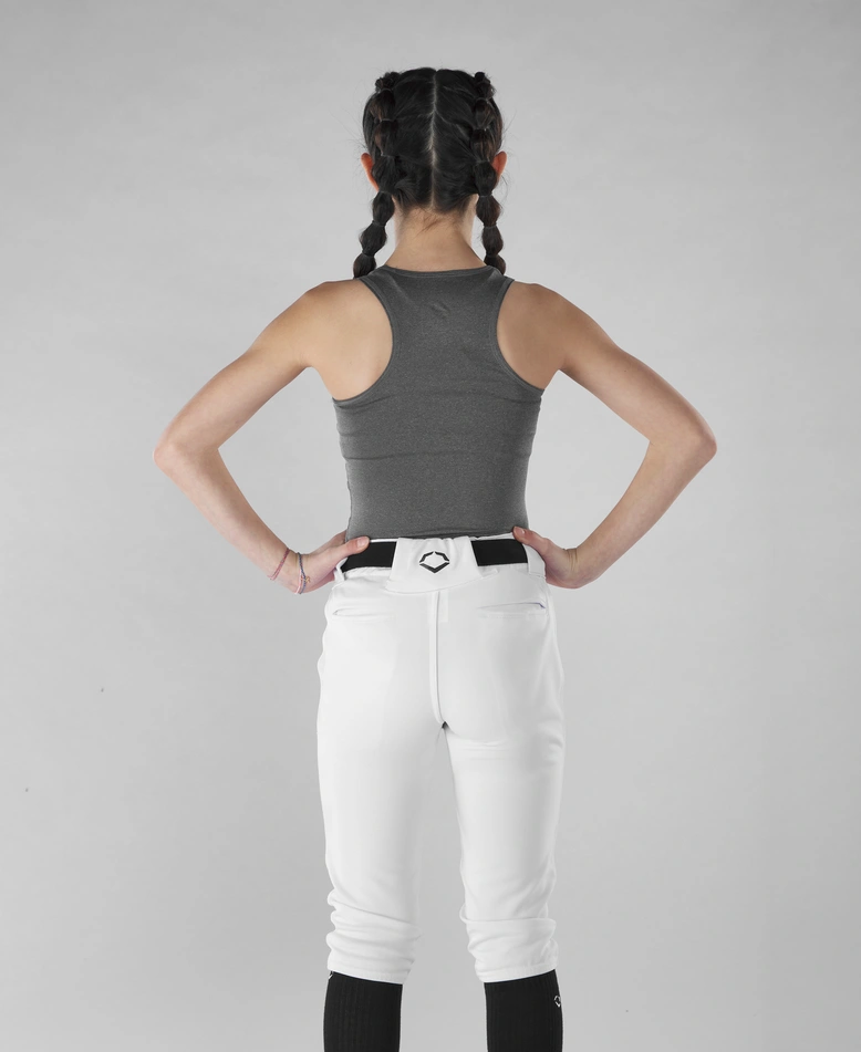 A girl with braids wearing white pants and an EvoShield Women's Racerback Chest Guard Sleeveless Shirt.