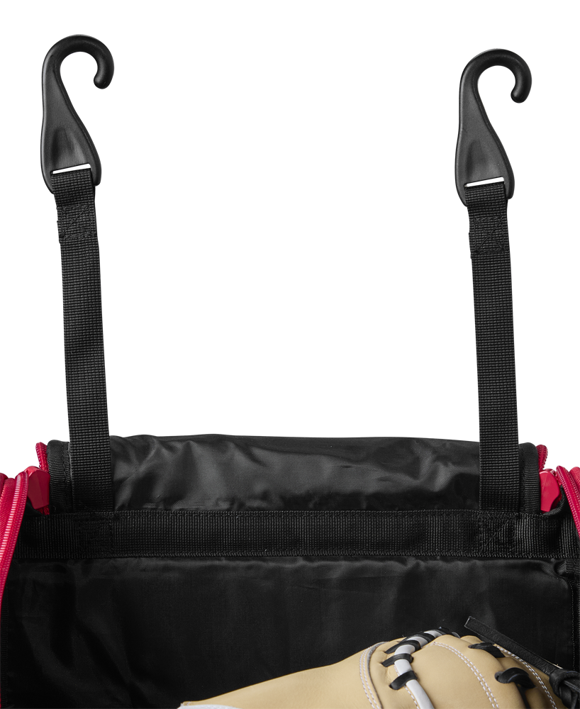 A close-up of the EvoShield Takeover Wheeled Bag (WB57572) in black and red, featuring two black straps with plastic hooks and part of a tan baseball glove visible inside the open bag.