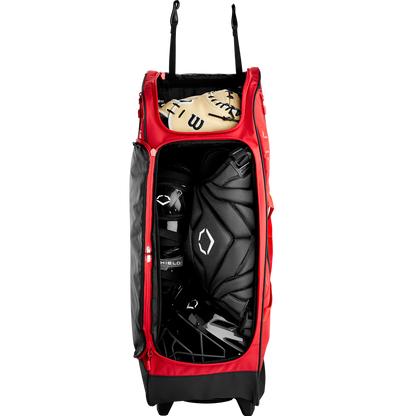The EvoShield Takeover Wheeled Bag (WB57572) by EvoShield, shown in red and unzipped to reveal black catcher's gear and a tan glove inside, is displayed against a plain white background.