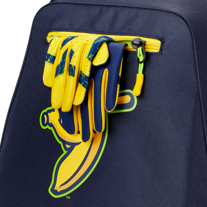 A pair of yellow and blue sports gloves is tucked into the pocket of a navy Louisville Slugger Savannah Bananas Powerized Stick Pack Backpack (WB57636), which features a graphic yellow banana.