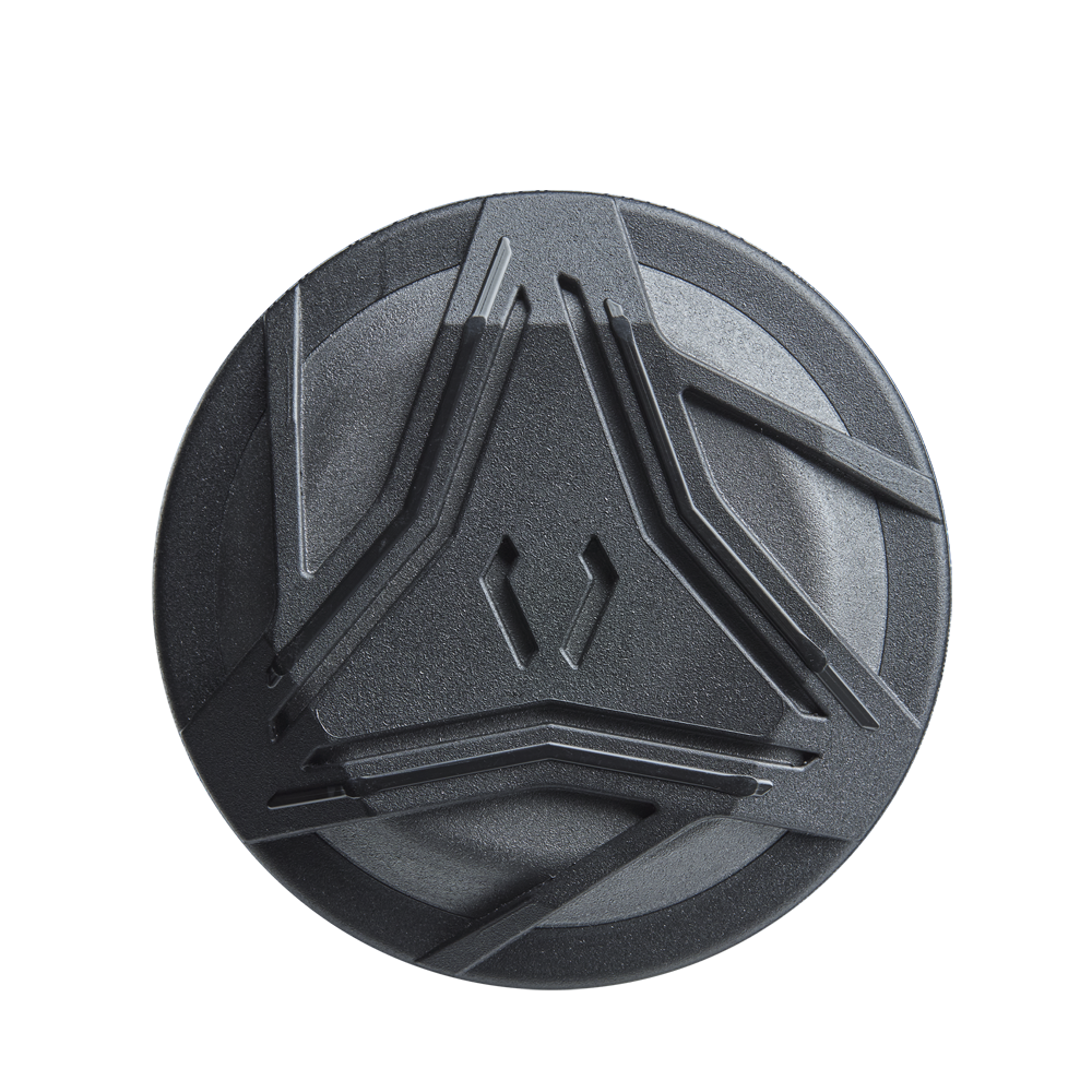 A round, dark gray object with raised angular designs—resembling the detailing of the DeMarini ZEN Limited Edition (-10) USSSA Baseball Bat (WBD2541010) by DeMarini—set against a plain white background.