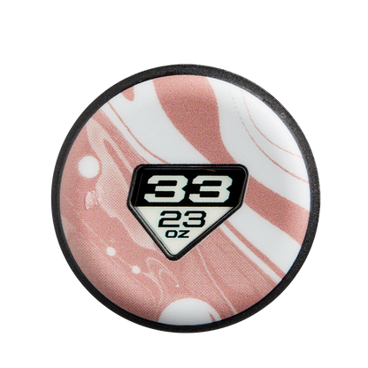 A round white and pink swirled object resembling a 2025 DeMarini Whisper (-10) Fastpitch Softball Bat: WBD2544010 features a black-edged diamond label, with "33" above "23 oz" in bold black at the center, echoing DeMarini's signature design.