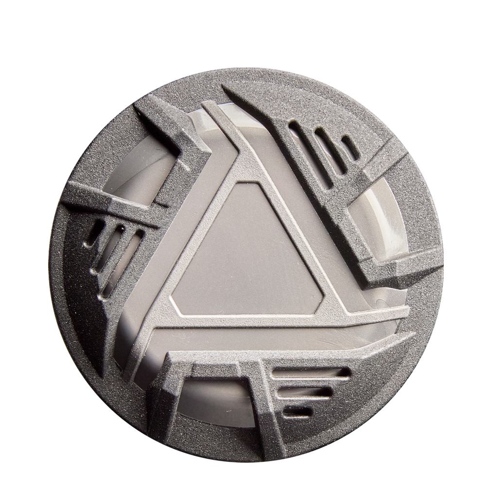 A round, metallic gray object with an angular geometric design rests on a white background, its look inspired by the advanced engineering of the 2026 DeMarini ZEN (-10) USSSA Baseball Bat by DeMarini.