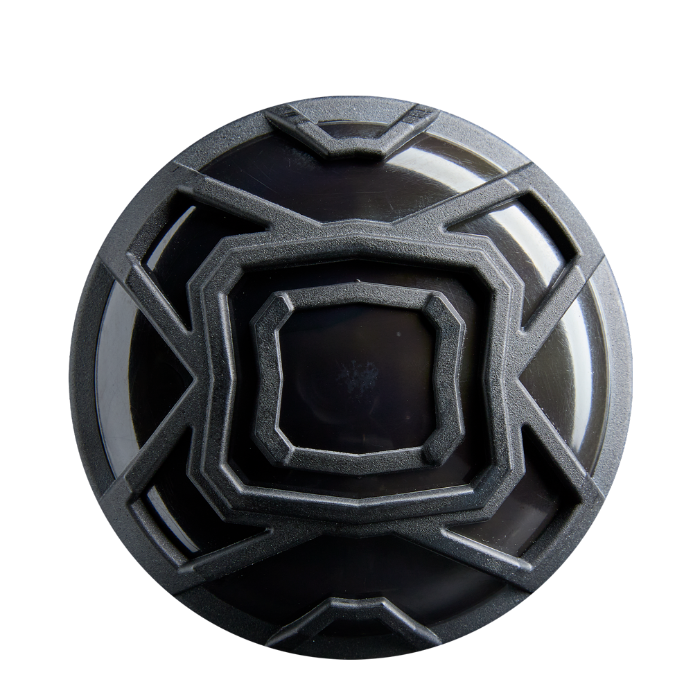 A round, black object with a geometric pattern of raised metallic lines, resembling the 2026 DeMarini The Goods Royal Purple (-3) BBCOR Baseball Bat: WBD2634010 by DeMarini, is seen from above against a white background.