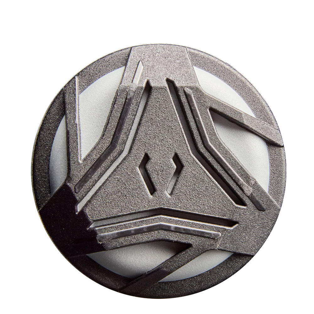 A circular metallic badge with an abstract geometric design of raised angular lines, inspired by the 2026 DeMarini Prism+ (-11) Fastpitch Softball Bat: WBD2636010 from DeMarini, displayed on a white background.