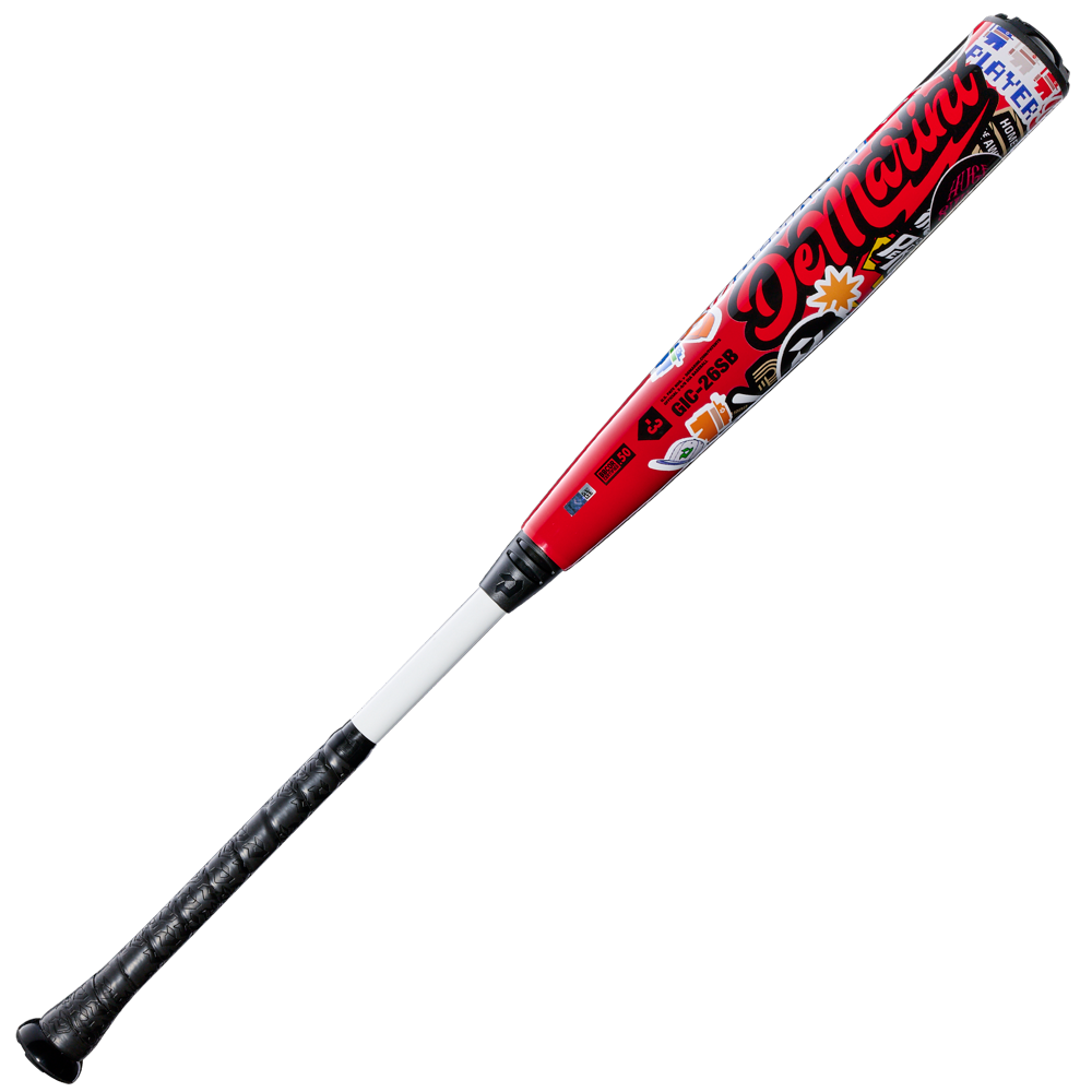A red and black 2026 DeMarini The Goods Sticker Bomb (-3) BBCOR Baseball Bat (WBD2653010) with a black grip, large DeMarini branding, and colorful graffiti-style sticker bomb designs.