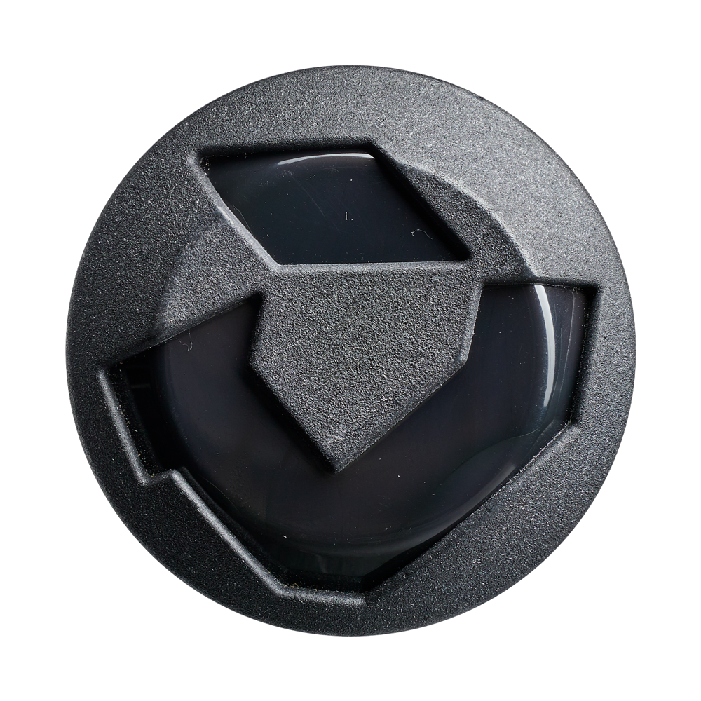 A black, circular object with a geometric, shield-like design—echoing the 2027 DeMarini Juggy Extended 13" Endload USA Slowpitch Softball Bat's barrel—displays three raised sections and a glossy center against a plain white background.