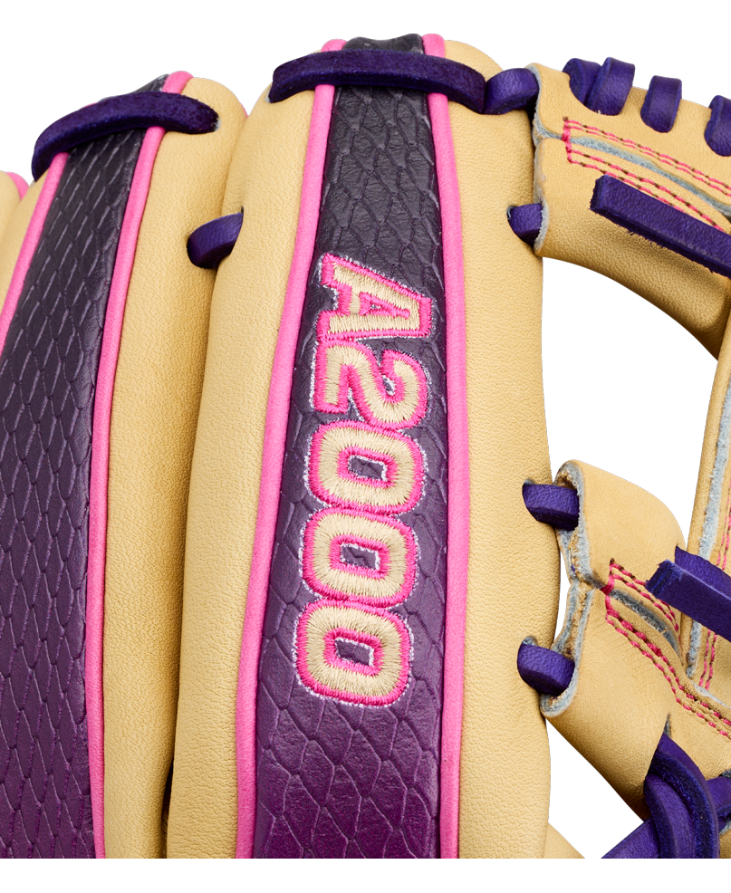 Close-up of a tan, purple, and pink Wilson 11.5″ infield baseball glove with “A2000” embroidered in pink on a purple strip. Designed for quick transfers and precision, this glove is crafted as the Wilson A2000 1720SS (WBG0009401RT115).
