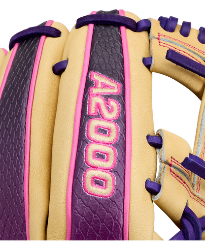 Close-up of a tan, purple, and pink Wilson 11.5″ infield baseball glove with “A2000” embroidered in pink on a purple strip. Designed for quick transfers and precision, this glove is crafted as the Wilson A2000 1720SS (WBG0009401RT115).