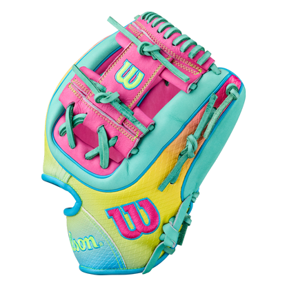 The Wilson A2000 1727SS 11.5″ Baseball Glove (WBG0009501RT1175) by Wilson showcases vibrant pink, yellow, teal, and light blue accents, bold stitching, advanced SuperSnakeSkin backing for lightweight durability, and is adorned with the signature Wilson W logo on the thumb and wrist area.