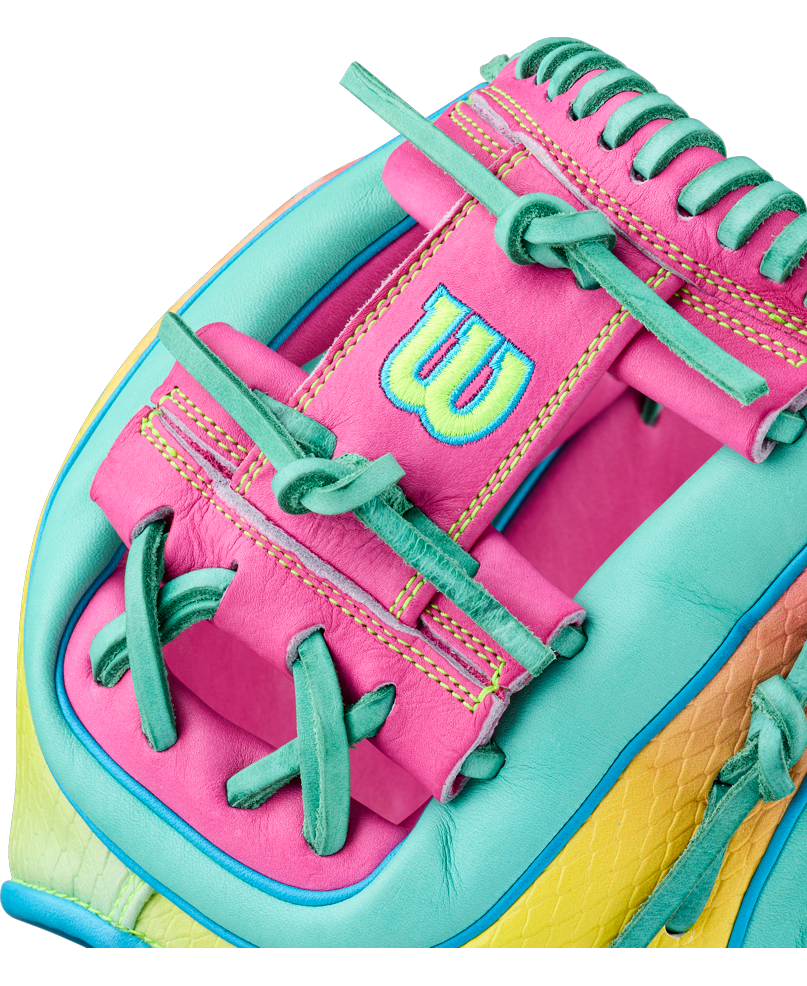 A close-up of the Wilson A2000 1727SS 11.5″ Baseball Glove (WBG0009501RT1175) by Wilson, showcasing its vibrant pink, teal, yellow, and green leather with detailed stitching, SuperSnakeSkin accents, and a prominently embroidered W logo.