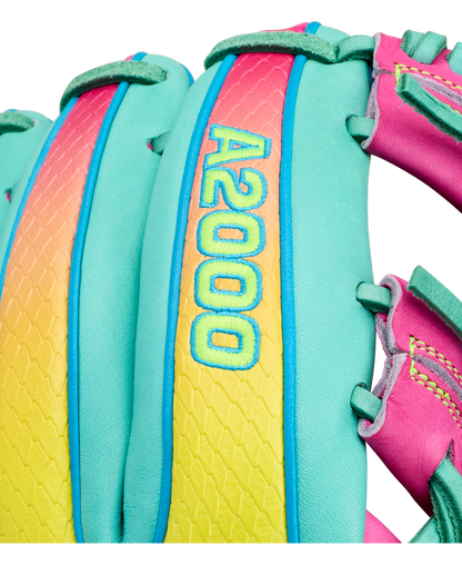 Close-up of a colorful Wilson A2000 1727SS 11.5″ Baseball Glove (WBG0009501RT1175) with “A2000 1727SS” embroidered in yellow and blue on a vibrant pink, yellow, and teal background. This Wilson glove features SuperSnakeSkin material, complemented by teal, pink, and green stitching and laces.