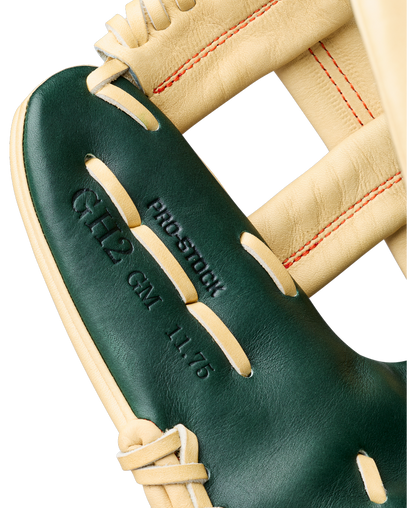 Close-up of a Wilson A2000 GH2 11.75″ Gunnar Henderson GM Baseball Glove (WBG0009601RT1175) featuring green and tan leather, red stitching, and embossed text reading PRO STOCK, 6H2 CM 11.75.