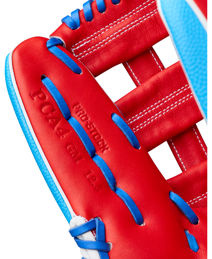Close-up of a red Wilson A2000 PCA4 12.5″ Pete Crow-Armstrong GM baseball glove (WBG0009701) by Wilson, featuring blue laces and white stitching. The palm area is embossed with PRO4-12GM 12.5 and PRO-STOCK.