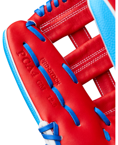Close-up of a red Wilson A2000 PCA4 12.5″ Pete Crow-Armstrong GM baseball glove (WBG0009701) by Wilson, featuring blue laces and white stitching. The palm area is embossed with PRO4-12GM 12.5 and PRO-STOCK.