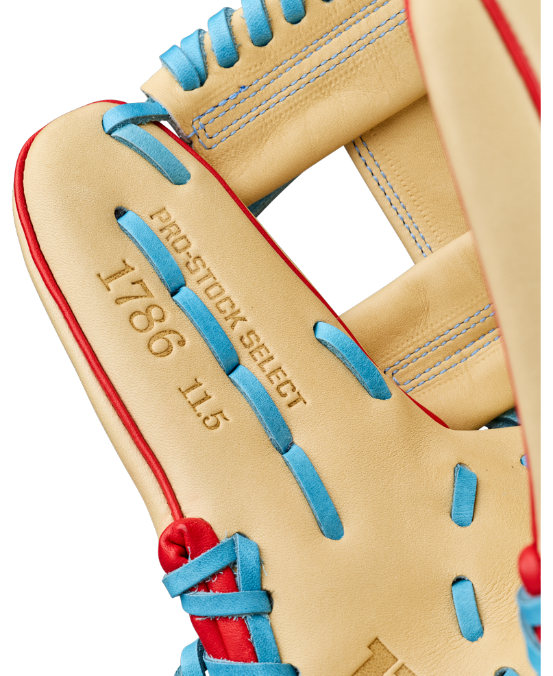 Close-up of a Wilson A2K 1786 11.5″ Baseball Glove (WBG0010101RT115), featuring tan Pro Stock Select leather accented with red and blue laces. The infield glove showcases gold stamping of PRO-STOCK SELECT, 1786, and 11.5 on the inside palm area.
