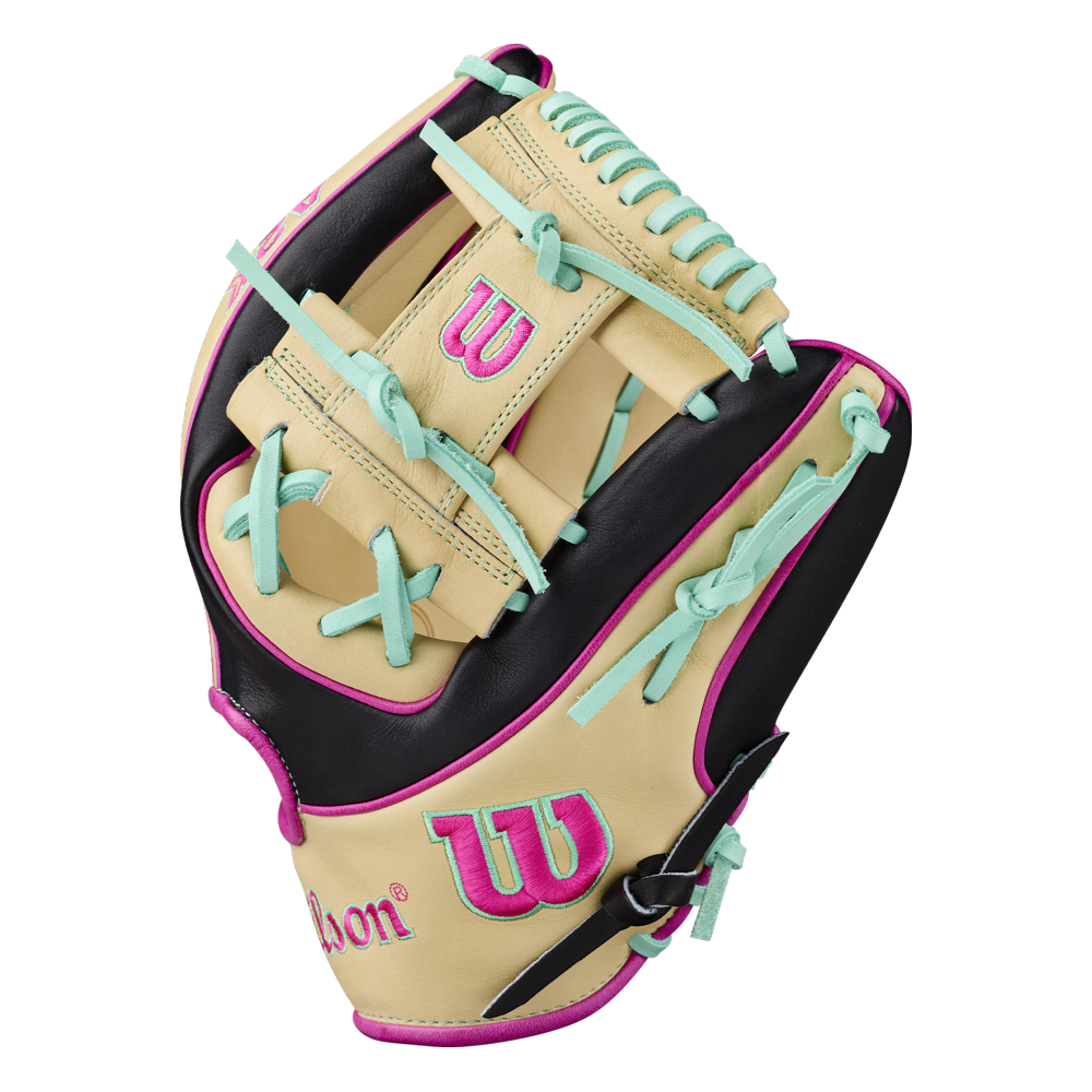 A Wilson A2K 1724 11.75″ Baseball Glove (WBG0010201RT1175) in tan, black, and pink—with teal laces, logo, and stitching accents—designed for infielders and built with Double Palm Construction from the Wilson brand is displayed from the side on a white background.