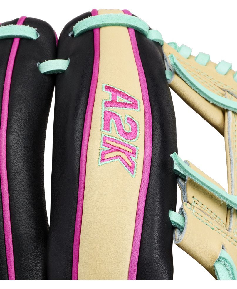 Close-up of a Wilson A2K 1724 11.75″ Baseball Glove (WBG0010201RT1175) by Wilson, specially crafted for infielders, displaying “A2K” embroidered in pink and blue on a tan leather section. The image emphasizes the Double Palm Construction as well as the glove’s black, teal, and pink accents.